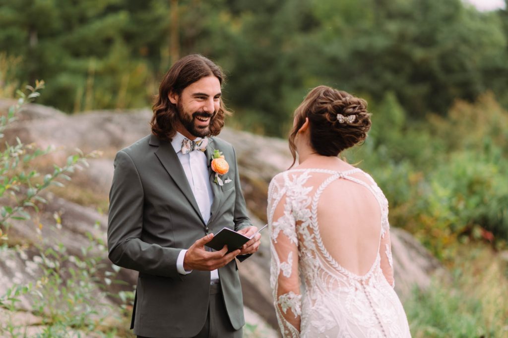 Tia and Matteo hold hands during their outdoor ceremony under a wooden pavilion with sweeping views.
